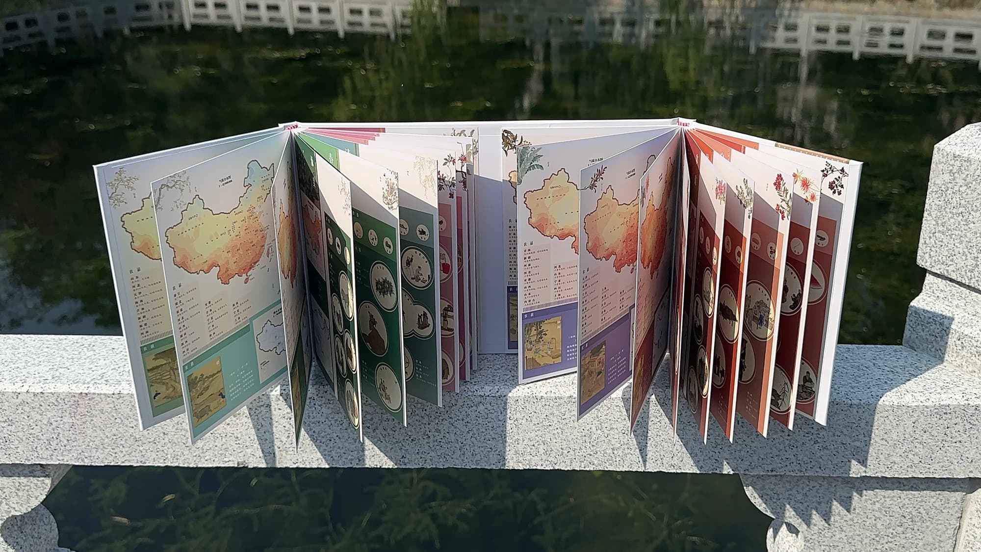 二十四节气地图集的双开门蝴蝶装实物，在展开与跨页中形成连续阅读。